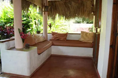 a porch with a bench in front of a window at Palm-covered house in the tropical -Casa Oli in Las Galeras