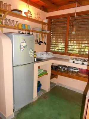 a kitchen with a stainless steel refrigerator in a kitchen at Casa 3 amigos-Palm roofed house in Las Galeras