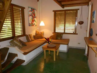 a living room with a bed and a table at Casa 3 amigos-Palm roofed house in Las Galeras
