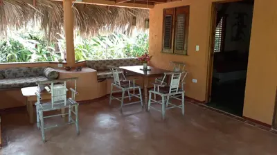 a dining room with a table and chairs in a house at Casa 3 amigos-Palm roofed house in Las Galeras