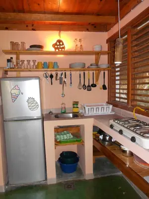 a kitchen with a refrigerator and a sink at Casa 3 amigos-Palm roofed house in Las Galeras