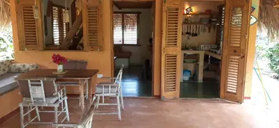 a kitchen and dining room with a table and chairs at Casa 3 amigos-Palm roofed house in Las Galeras