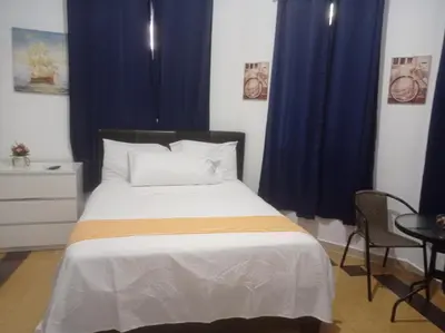 a bedroom with a large bed with blue curtains at Hostal Mi Rincón in Santo Domingo