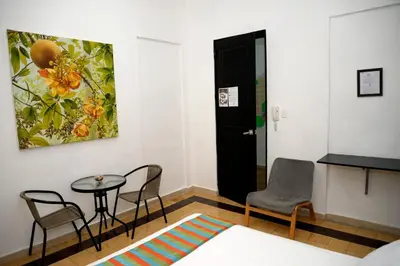 a room with a table and chairs and a door at Hostal Mi Rincón in Santo Domingo