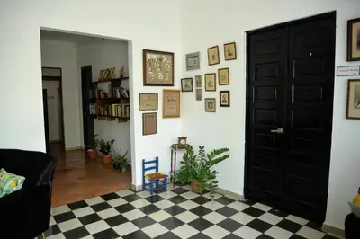 a living room with a black door and a checkered floor at Hostal Mi Rincón in Santo Domingo