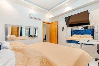 a bedroom with two beds and a flat screen tv at Cozy Apartment near Downtown Center in Santo Domingo