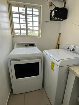 a small kitchen with a washing machine and a window at Paramount 3-Bedroom Apartment with Parking in San Felipe de Puerto Plata