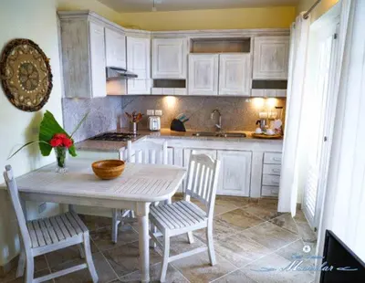 a kitchen with a table and two chairs and a table and a kitchen at Hotel Residence Marilar in Las Terrenas