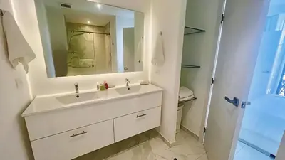 a bathroom with a white sink and a mirror at Cana Rock Star Pool View Whith BBQ in Punta Cana