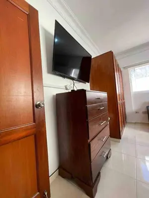 a living room with a flat screen tv on a wall at Entire Apartment Tu Nido De Amor netflix Wifi in Santo Domingo