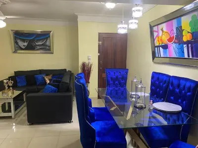 a living room with blue chairs and a glass table at Entire Apartment Tu Nido De Amor netflix Wifi in Santo Domingo