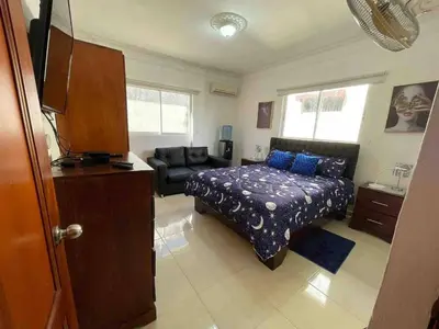 a bedroom with a bed and a couch at Entire Apartment Tu Nido De Amor netflix Wifi in Santo Domingo