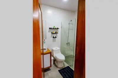 a bathroom with a toilet and a glass shower at Hermoso apartamento, 3 Habitaciones espaciosas, 2 Aires acondicionados in Santiago de los Caballeros