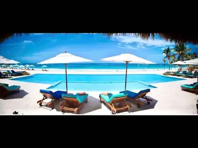 a group of chairs and umbrellas on a swimming pool at Cana Rock Chic Golf de Lux in Punta Cana