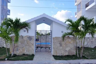 a white building with palm trees in front of it at CASA MARAVILLOSA in Bayahibe