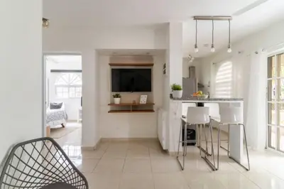 a kitchen with white walls and a table and chairs at Cozy 2 bdr condo, with pool area and free WIFI in Punta Cana
