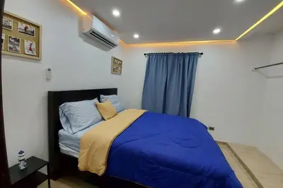 a bedroom with a bed with blue sheets and a window at Cómodo Apto de 2hab con Aire 2baños, cerca de todo en Alma Rosa I in El Seis