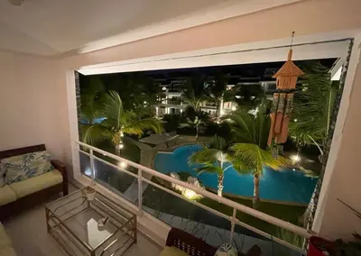 a room with a large window with a view of a resort at Casa en Paraiso RD in Bayahibe