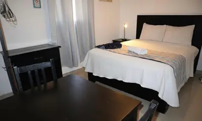 a hotel room with a bed with a table and a table sidx sidx at RIG Casa Conde in Santo Domingo