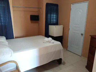 a bedroom with a white bed and a white refrigerator at Apartahotel Next Nivel - Queen Room in Punta Cana