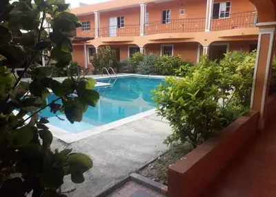 a swimming pool in front of a building at Apartahotel Next Nivel - Queen Room in Punta Cana
