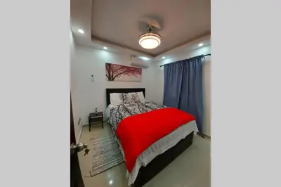 a bedroom with a bed with a red blanket at 4to nivel 2 habitaciones 2 baños Alma Rosa I in El Seis