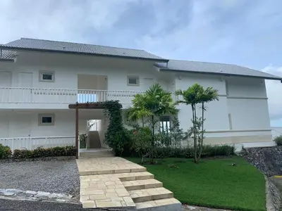 a white house with palm trees in front of it at Spectacular Ocean View Spacious 2-Bedroom Condo, Vista Mare, Samana DR in Santa Bárbara de Samaná