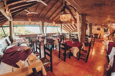 a restaurant with tables and chairs in a building at Altos de Caño Hondo in Los Guineos Perdidos