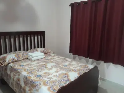 a bedroom with a bed with a comforter on it at Apartahotel Next Nivel - Queen Room with Fan in Punta Cana