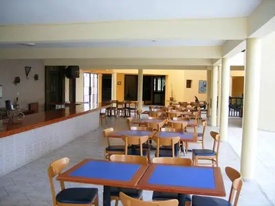 a dining room with tables and chairs and a bar at Hotel Las Caobas in San Francisco de Macorís