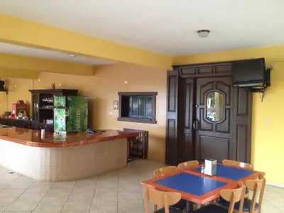 a restaurant with a bar with a table and chairs at Hotel Las Caobas in San Francisco de Macorís