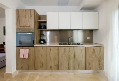a kitchen with wooden cabinets and a sink at Amar'e Aparthotel & Spa in Las Terrenas