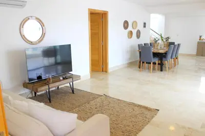 a living room with a television and a table with chairs at Amar'e Aparthotel & Spa in Las Terrenas