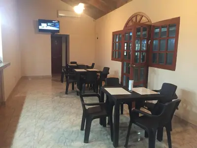 a dining room with tables and chairs and a tv at Hotel Santander SD in Santo Domingo