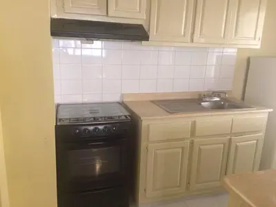 a kitchen with a black stove and a sink at Hotel Santander SD in Santo Domingo