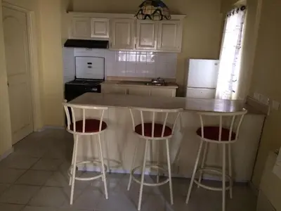 a kitchen with two bar stools and a counter top at Hotel Santander SD in Santo Domingo