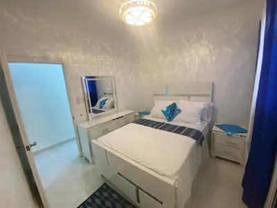 a small bedroom with a bed and a mirror at 7DR Apt in Prime Location Near Monumental Area in Santiago de los Caballeros