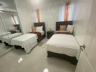 a bedroom with two beds and a mirror at 7DR Apt in Prime Location Near Monumental Area in Santiago de los Caballeros