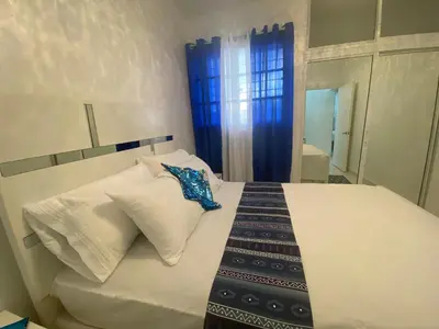 a bedroom with a bed with white pillows and a mirror at 7DR Apt in Prime Location Near Monumental Area in Santiago de los Caballeros