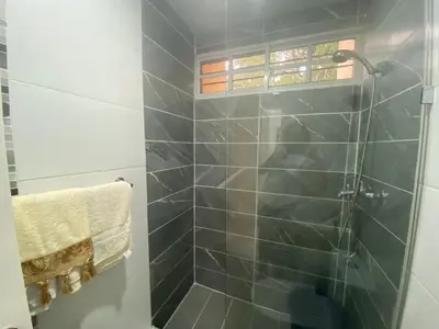 a bathroom with a shower with blue tiles at 7DR Apt in Prime Location Near Monumental Area in Santiago de los Caballeros
