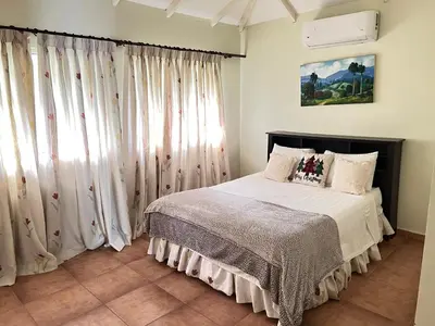 a bedroom with a bed with white curtains at El Yaguacil Aparta Hotel in Jarabacoa