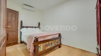 a bedroom with a bed and a wooden door at El Yaguacil Aparta Hotel in Jarabacoa