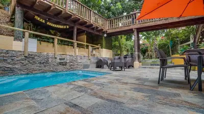 a patio with an umbrella and a swimming pool at El Yaguacil Aparta Hotel in Jarabacoa