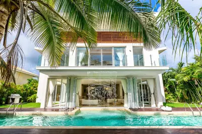 a house with a swimming pool in front of a house at Best Private Cocotal Villas in Punta Cana in Punta Cana