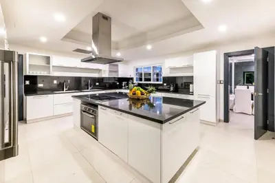 a kitchen with white cabinets and a black counter top at Best Private Cocotal Villas in Punta Cana in Punta Cana
