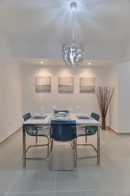 a dining room table with chairs and a chandelier at Dom. Rep. Exclusive 2 bed Apt. Evaristo Morales in Santo Domingo