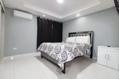 a bedroom with a bed and a black curtain at Hotel Señorial in Santo Domingo