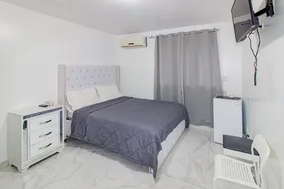 a bedroom with a bed and a dresser and a television at Hotel Señorial in Santo Domingo