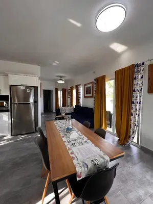a kitchen and living room with a wooden table and chairs at Apartamento Carey in Cabrera
