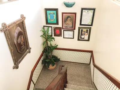 a staircase with pictures on the wall and a plant at Hotel Sinai in Nagua